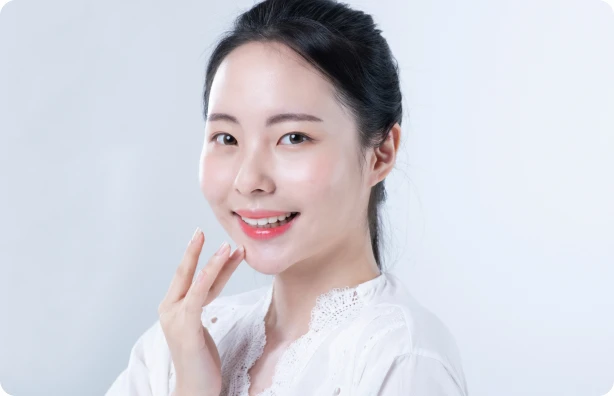 턱 아래에 손을 대고 미소 짓는 여성