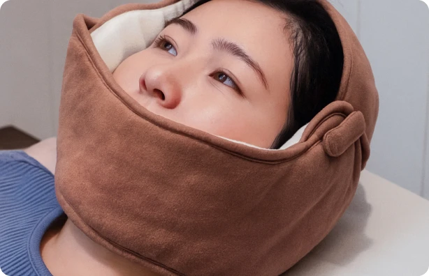 얼굴을 감싸는 온습열 찜질팩을 착용한 모습