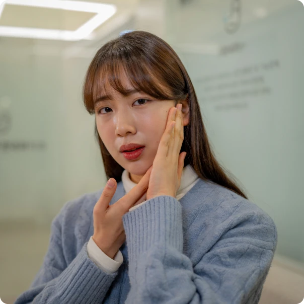 양손으로 턱을 감싸며 통증을 호소하는 환자