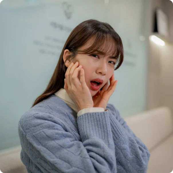 턱을 붙잡고 입을 벌리기 힘들어하는 환자