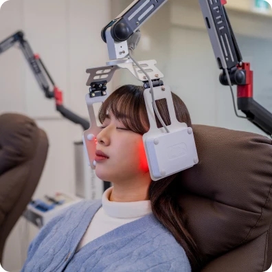 레이저 치료 장비를 얼굴에 맞추고 누워 있는 환자