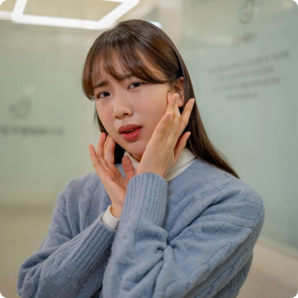 양 볼을 손으로 감싸며 얼굴 통증을 호소하는 여성