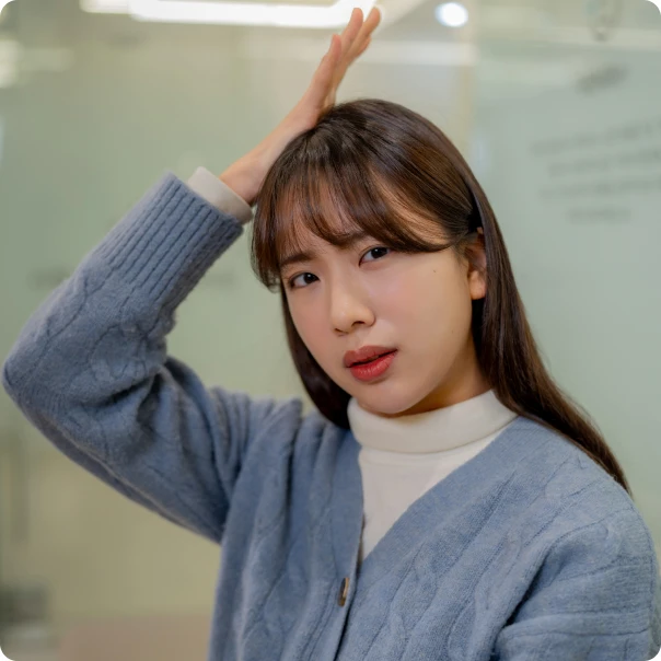 한 손으로 머리를 짚으며 얼굴 통증을 호소하는 여성