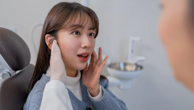 진료 의자에서 턱 상태를 확인받는 환자