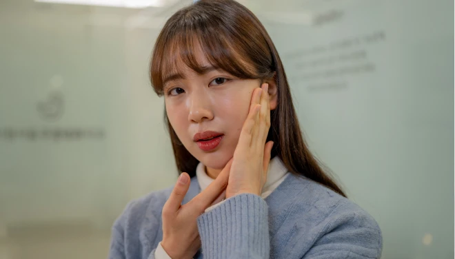 턱 옆을 손으로 감싸며 통증을 호소하는 환자