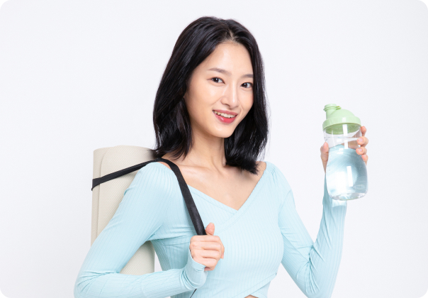 웃는 얼굴로 요가 매트를 메고 물통을 든 젊은 여성